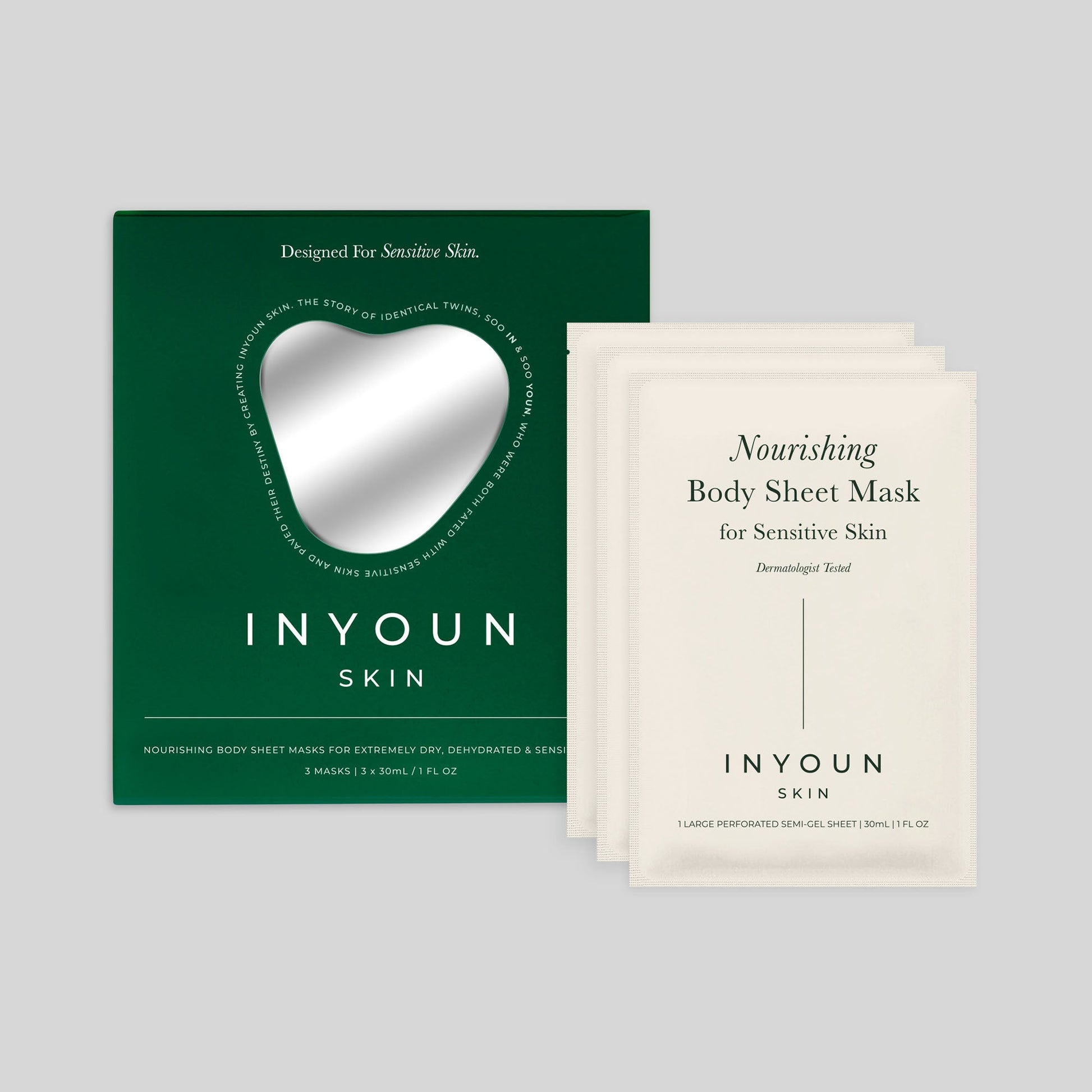 Front view of nourishing body sheet mask showing green box with heart window and three sachets on gray background